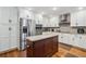 Spacious kitchen featuring stainless steel appliances, white cabinets, granite countertops and a kitchen island at 212 Wilshire Ter, White, GA 30184