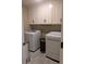 Well-equipped laundry room with modern washer and dryer units and overhead cabinets at 212 Wilshire Ter, White, GA 30184