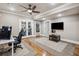 Living room with ceiling fan, TV, and french doors to exercise room at 212 Wilshire Ter, White, GA 30184