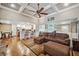 Bright living room featuring hardwood floors, a coffered ceiling with fan, and seamless transition to a modern kitchen at 212 Wilshire Ter, White, GA 30184
