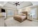 Serene bedroom features a tray ceiling with fan, neutral tones, carpet, and ample natural light at 212 Wilshire Ter, White, GA 30184