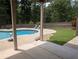 Beautiful backyard pool featuring well-manicured lawn and mature trees at 212 Wilshire Ter, White, GA 30184
