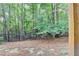 View of wooded backyard from below the deck with wrought iron fence at 5207 Merrimont Dr, Alpharetta, GA 30022