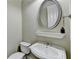 Bathroom featuring a rounded mirror, white sink, toilet, and neutral paint at 5207 Merrimont Dr, Alpharetta, GA 30022