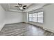 Spacious bedroom featuring sleek gray floors, large windows, and a modern ceiling fan at 5207 Merrimont Dr, Alpharetta, GA 30022