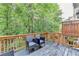 View of deck with wood railing and treed backyard at 5207 Merrimont Dr, Alpharetta, GA 30022