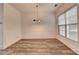 Dining room featuring gray wood-look floors, modern chandelier, and large window providing ample natural light at 5207 Merrimont Dr, Alpharetta, GA 30022