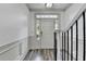 Bright entryway featuring a black handrail, white door with a window and hardwood style floors at 5207 Merrimont Dr, Alpharetta, GA 30022