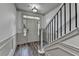 Elegant entryway with gray floors, white trim, and staircase with black iron spindles at 5207 Merrimont Dr, Alpharetta, GA 30022