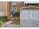 Inviting brick exterior showcases a two-car garage, landscaped entry, and classic architectural details at 5207 Merrimont Dr, Alpharetta, GA 30022