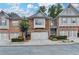 Charming brick townhome featuring a two-car garage, landscaped front yard, and inviting curb appeal at 5207 Merrimont Dr, Alpharetta, GA 30022