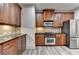 Well-equipped kitchen with stainless steel appliances and rich wood cabinetry at 5207 Merrimont Dr, Alpharetta, GA 30022