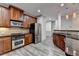 Open kitchen with stainless steel appliances, granite countertops, and gray wood-look flooring at 5207 Merrimont Dr, Alpharetta, GA 30022
