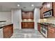 Updated kitchen featuring rich wood cabinets, black countertops, and stainless-steel appliances at 5207 Merrimont Dr, Alpharetta, GA 30022