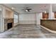 Open-concept living room features a stone fireplace, ceiling fan, and modern gray wood-look floors at 5207 Merrimont Dr, Alpharetta, GA 30022