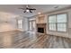 Spacious living room with a stone fireplace, modern floors, ceiling fan, and plenty of natural light at 5207 Merrimont Dr, Alpharetta, GA 30022
