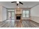 Living room features a stone fireplace, ceiling fan, modern floors and a door leading to an outdoor deck at 5207 Merrimont Dr, Alpharetta, GA 30022
