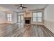 Spacious living room with a stone fireplace, modern floors, ceiling fan, and plenty of natural light at 5207 Merrimont Dr, Alpharetta, GA 30022