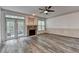 Living room features a stone fireplace, ceiling fan, modern floors and a door leading to an outdoor deck at 5207 Merrimont Dr, Alpharetta, GA 30022