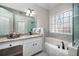 Elegant bathroom with granite counters, soaking tub, decorative window and glass shower at , Lilburn, GA 30047