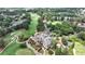 Aerial view of golf course and clubhouse in a neighborhood featuring lush greenery and manicured landscaping at 119 Kennemer Ct, Duluth, GA 30097