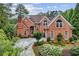 Beautiful red brick house with lush greenery, an arched entryway, and grand curb appeal at 119 Kennemer Ct, Duluth, GA 30097