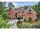 A beautiful red brick house with an arched doorway and lots of flowering bushes at 119 Kennemer Ct, Duluth, GA 30097