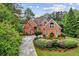 Charming brick residence surrounded by trees and featuring a well-maintained lawn and a long driveway at 119 Kennemer Ct, Duluth, GA 30097