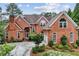 Beautiful red brick home showcasing a symmetrical facade and a charming front yard at 119 Kennemer Ct, Duluth, GA 30097