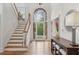 Bright foyer featuring wood floors, staircase, high ceilings, and decorative glass entryway at 119 Kennemer Ct, Duluth, GA 30097