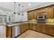 Well-lit kitchen featuring stainless steel appliances, custom wood cabinetry and granite countertops at 119 Kennemer Ct, Duluth, GA 30097