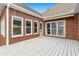 Spacious back deck featuring white washed wood, brick exterior, and access to the house through multiple windows at 2260 Burlington Ln, Snellville, GA 30078