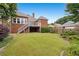 View of the backyard with a deck, stairs, and a well-maintained lawn surrounded by garden beds at 2260 Burlington Ln, Snellville, GA 30078