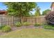 Landscaped backyard featuring a wooden fence, a large tree, and manicured garden beds at 2260 Burlington Ln, Snellville, GA 30078