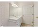 Traditional bathroom featuring a white vanity with ample countertop space, a large mirror, floral wallpaper and a tiled floor at 2260 Burlington Ln, Snellville, GA 30078