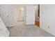 Bedroom featuring neutral carpeting, a glimpse into the attached bathroom, and a staircase through the opened doors at 2260 Burlington Ln, Snellville, GA 30078