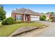 Well-maintained brick home features a manicured lawn and an attached garage with a concrete driveway at 2260 Burlington Ln, Snellville, GA 30078