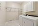 Well-equipped laundry room featuring a washer, dryer, and shelving for storage at 2260 Burlington Ln, Snellville, GA 30078