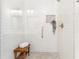 Modern shower featuring sleek white subway tile, a glass door, a built-in niche, and a wood bench at 2700 Pine Tree Ne Rd # 2201, Atlanta, GA 30324