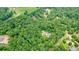 An aerial view shows a home with a pool nestled in a green, wooded setting at 326 Seldom Seen Trl, Canton, GA 30115