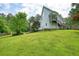 Side view of a white home with beautiful green lawn and mature trees at 326 Seldom Seen Trl, Canton, GA 30115