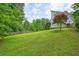 Backyard view of a white home with sprawling green lawn and mature trees at 326 Seldom Seen Trl, Canton, GA 30115