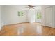 Spacious bedroom featuring hardwood floors, baseboard trim, and ample natural light from two windows at 326 Seldom Seen Trl, Canton, GA 30115