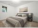 Staged bedroom featuring modern art, a gray upholstered headboard, and wood-look floors at 326 Seldom Seen Trl, Canton, GA 30115