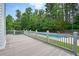 Spacious deck with gray floors overlooking private, fenced pool and wooded backyard at 326 Seldom Seen Trl, Canton, GA 30115