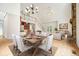 Open-concept dining room featuring a chandelier, an elegant table set for six, and hardwood floors at 326 Seldom Seen Trl, Canton, GA 30115