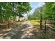 Gated driveway, lined with trees, leads to a charming white home at 326 Seldom Seen Trl, Canton, GA 30115