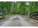 Gravel driveway winding through a tranquil, wooded landscape at 326 Seldom Seen Trl, Canton, GA 30115