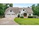 Charming two-story home features a well-manicured lawn, white siding, and an attached two-car garage at 326 Seldom Seen Trl, Canton, GA 30115