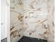 Modern shower featuring marble-patterned tile walls and black hexagon tile floor at 326 Seldom Seen Trl, Canton, GA 30115